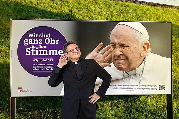 Bischof Felix Gmür vor Kampagnenplakat
