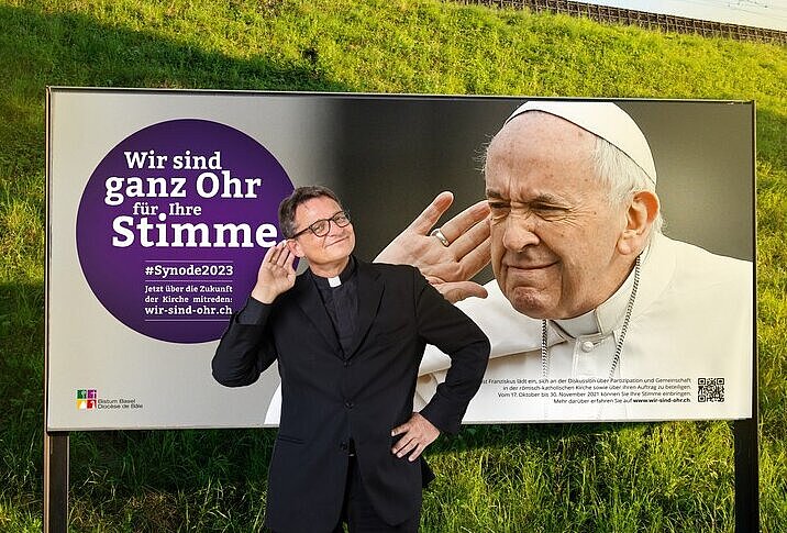 Bischof Felix Gmür vor Kampagnenplakat